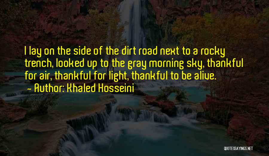 Khaled Hosseini Quotes: I Lay On The Side Of The Dirt Road Next To A Rocky Trench, Looked Up To The Gray Morning