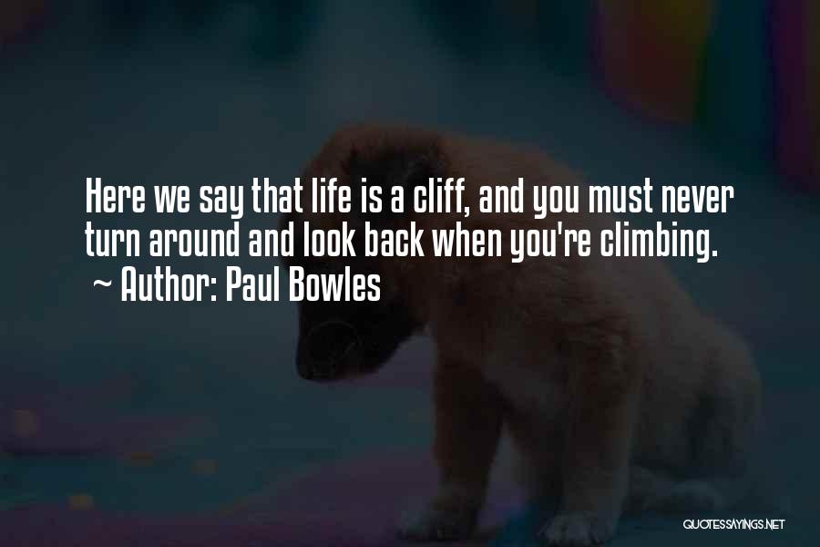 Paul Bowles Quotes: Here We Say That Life Is A Cliff, And You Must Never Turn Around And Look Back When You're Climbing.